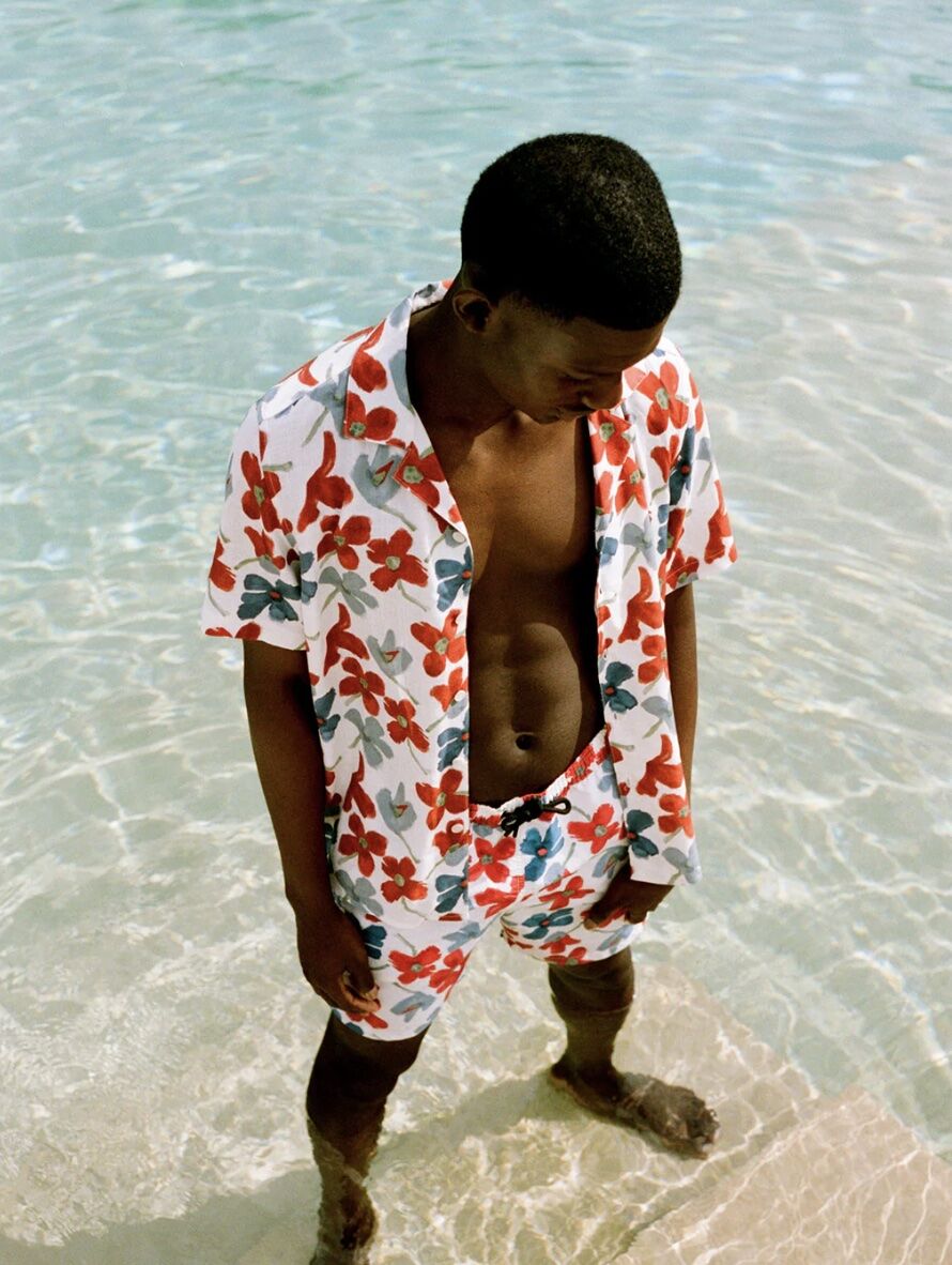 man wearing matching shirt and shorts standing in clear blue water