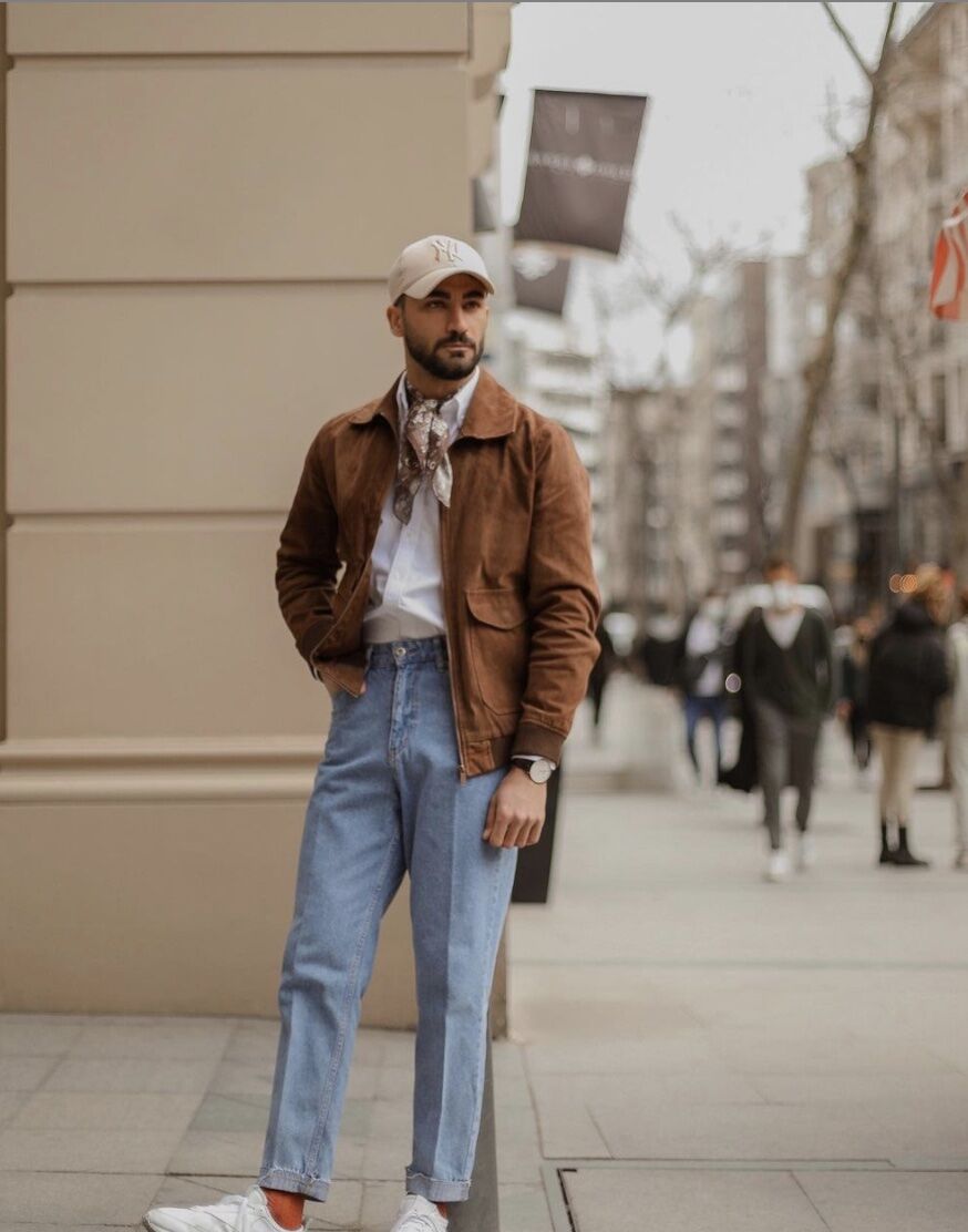 Man wearing non iron dress shirt with brown jacket, white sneakers, and pressed jeans 