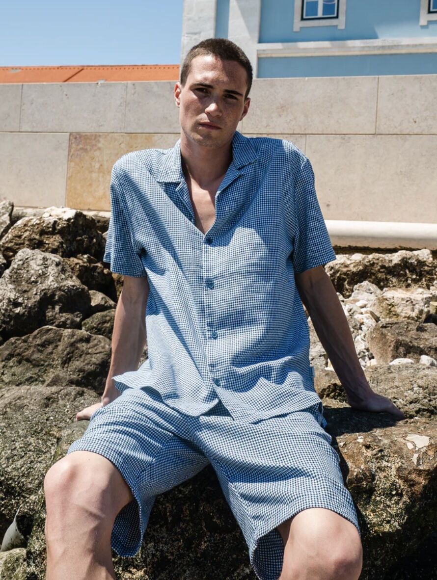 Man wearing matching shorts and shirt sitting on rocks