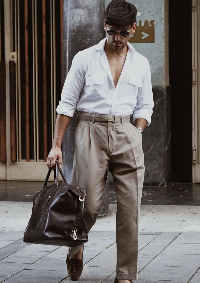 Man walking with a partially open shirt and a leather bag