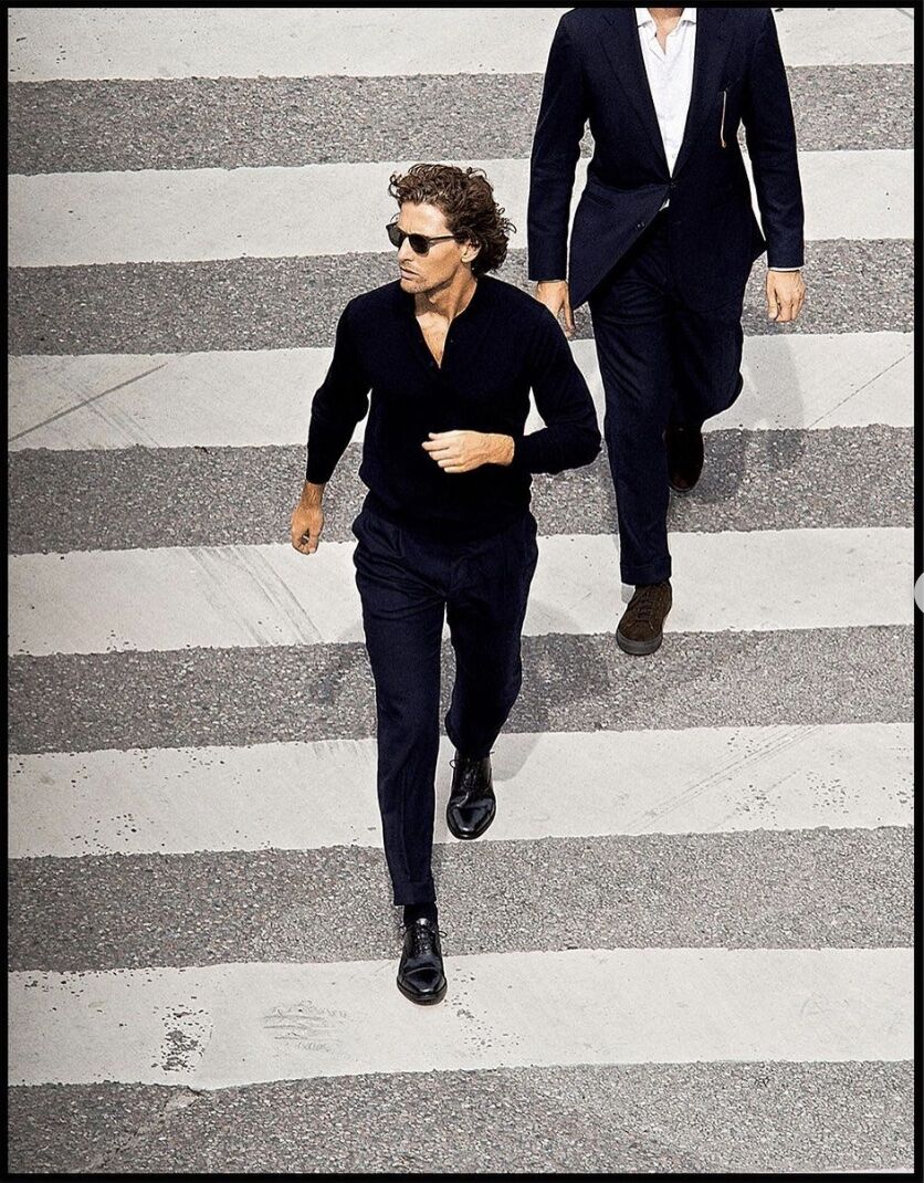 man walking across the stress in all black