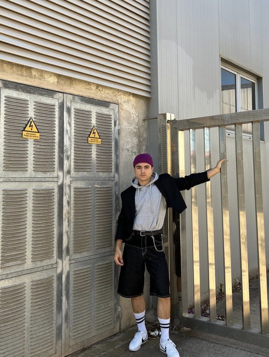 man leaning against a fence