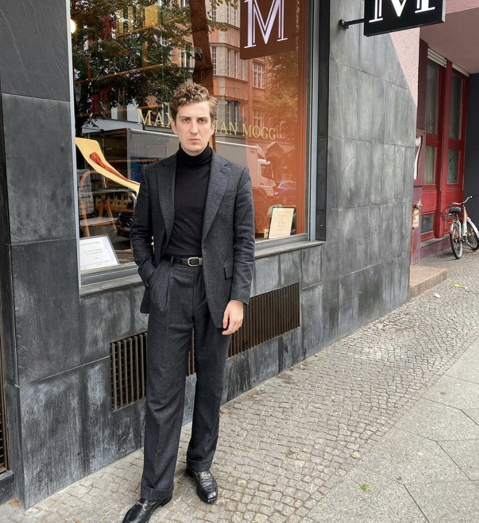 man wearing a suit in front of a store