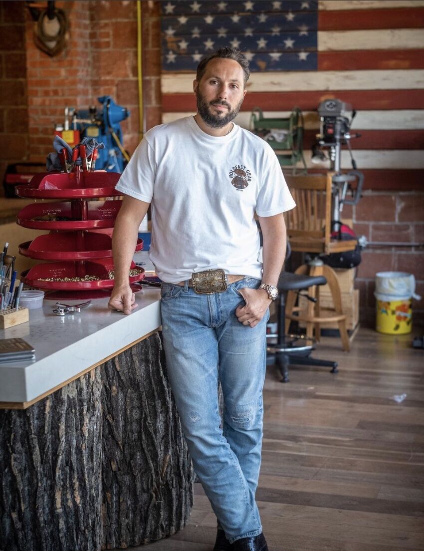 man leaning on a counter in a store wearing a snap belt