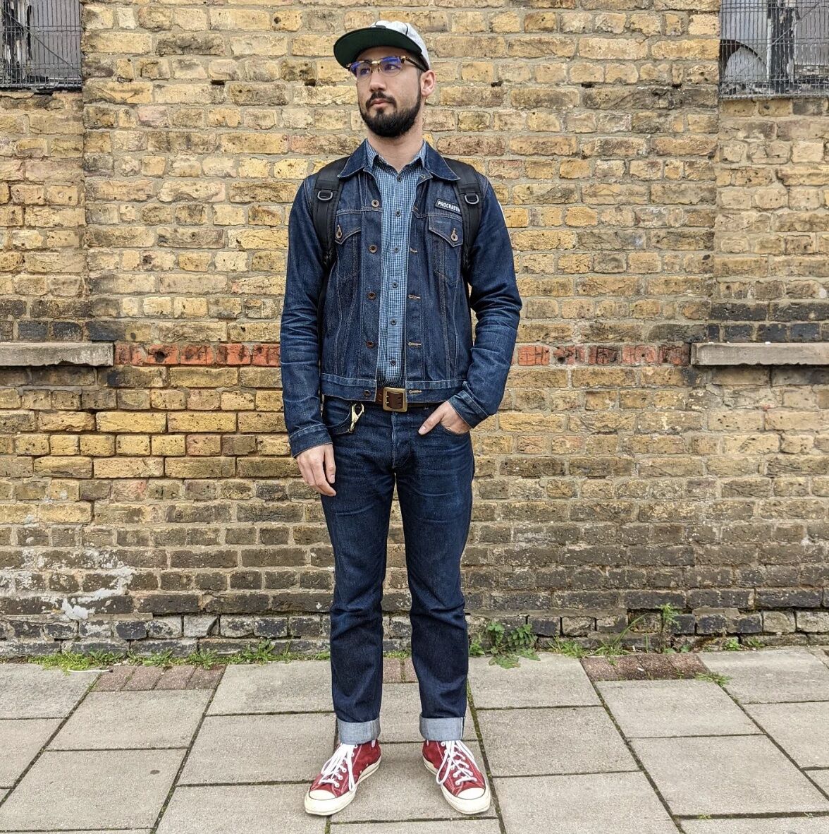 man standing in front of building wearing double denim