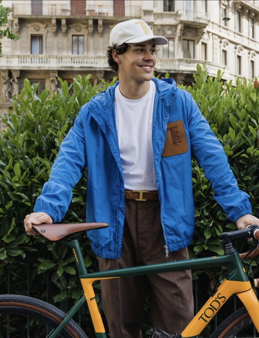 man standing holding a road bike