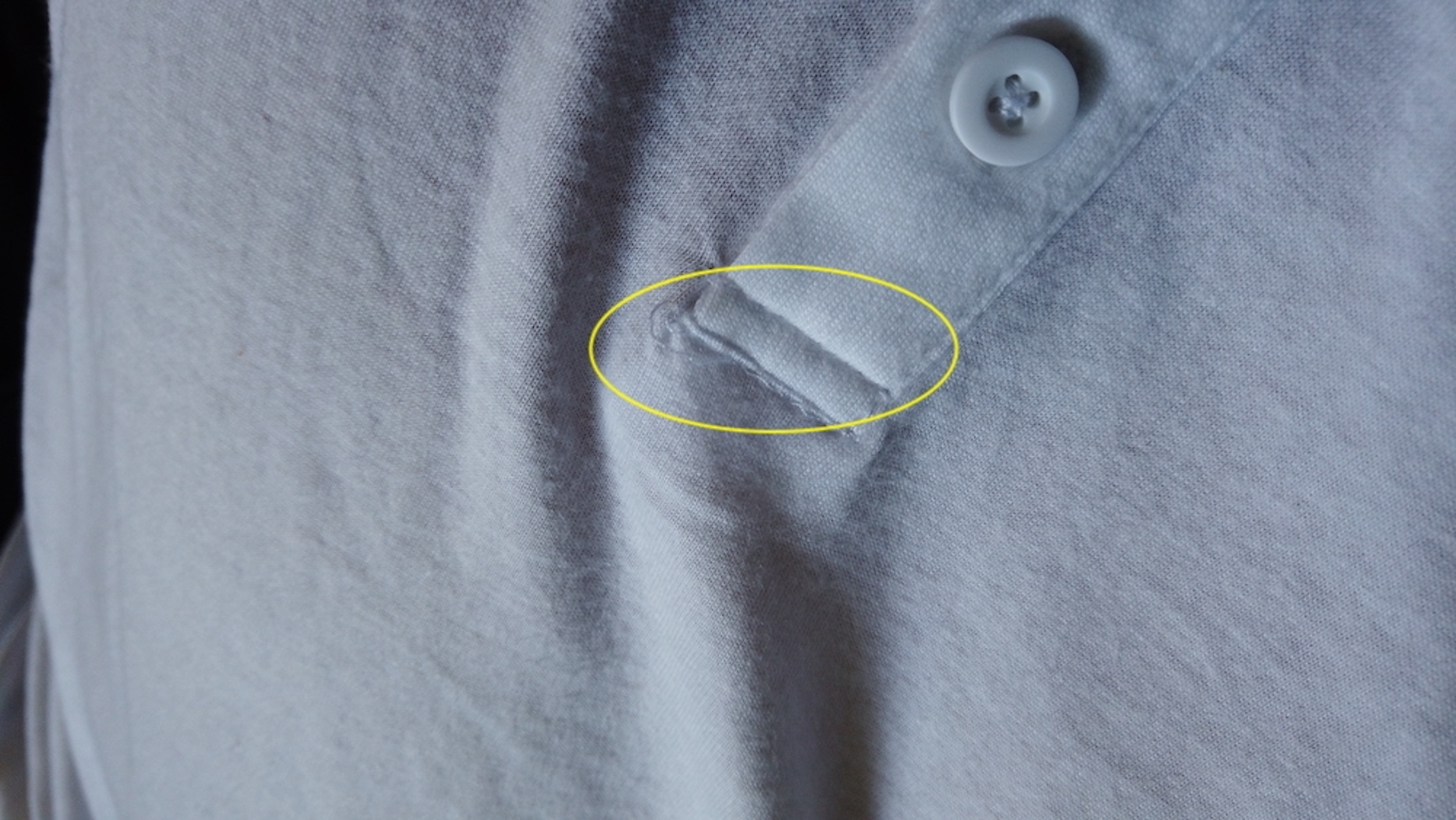 Image shows loose thread on a new long-sleeved henley
